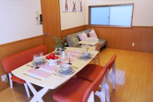 a dining room with a table and chairs and a couch at Rabbit Island Inn in Mihara +62 photos