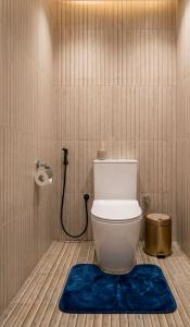a bathroom with a toilet with a blue rug at Sunshine Resort Sigiriya in Sigiriya +38 photos