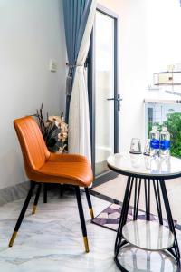 a chair and a table with water bottles on it at LUNA House in Can Tho +10 photos