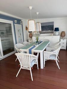 a dining room with a table and wicker chairs at Dolce Vita in Drage