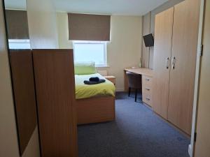 a small bedroom with a bed and a desk at Spa Court in Cheltenham +83 photos