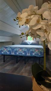 a bed in a room with white flowers on it at Climatisation avec La Rouyonnaise in Tinténiac +21 photos