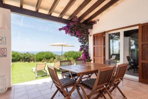 a patio with a wooden table and chairs at Villa Ribes by Escape Home in Binibeca