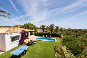 a garden with a swimming pool and a house at Villa Ribes by Escape Home in Binibeca