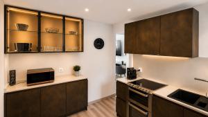 a kitchen with brown cabinets and a sink at DAJO Castel Lina in Cap d'Ail