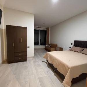 a bedroom with a large bed and a dresser at Plaza Central Boutique House in Cochabamba