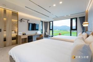 a hotel room with a bed and a desk and a television at 亮Villa in Sanxing