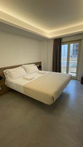 a large white bed in a room with a window at El Concept Room in Brolo