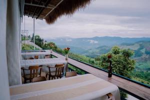 a room with a balcony with a view of mountains at Nontawa Villa Doichang in Ban Huai Khai
