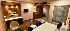 a hotel room with a bed and a mirror at Hotel Gentleman Plaza in Alleppey +8 photos
