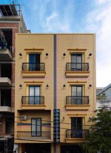 a yellow building with balconies on the side of it at LangX Chapter Hotel & Apartment in Danang