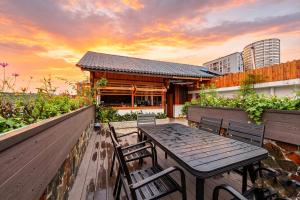 a table and chairs on a balcony with a building at Windmoon Hillcourt Tianmen Vis Lodge in Zhangjiajie