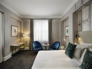 a hotel room with a bed and a desk and chairs at Fable Auckland, MGallery in Auckland
