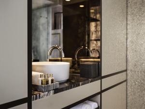 a bathroom with a sink and two faucets at Fable Auckland, MGallery in Auckland +116 photos