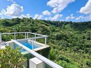 a villa with a swimming pool in the middle of a forest at Pousada Rota do Pilão in Araçoiaba