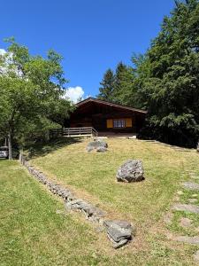 a log cabin with rocks in front of a house at Baita immersa nel verde in Salabertano
