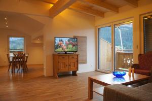 a living room with a flat screen tv on a dresser at Ferienwohnungen Perterer in Fieberbrunn