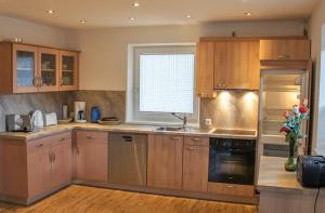 a large kitchen with wooden cabinets and a window at Ferienwohnungen Perterer in Fieberbrunn +5 photos