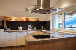 a kitchen with white cabinets and a sink and a window at Ferienwohnungen Perterer in Fieberbrunn