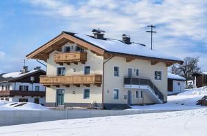 a large house with a snow covered roof at Ferienwohnungen Perterer in Fieberbrunn