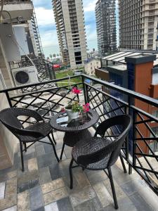 a balcony with chairs and a table with flowers on it at Apartnuca in Batumi