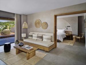 a bedroom with a bed and a living room at Rixos Premium Bodrum in Torba