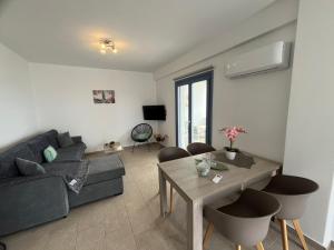 a living room with a couch and a table at Aegean Mirror Andros in Apróvaton