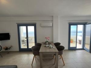 a living room with a table and chairs and a balcony at Aegean Mirror Andros in Apróvaton +13 photos