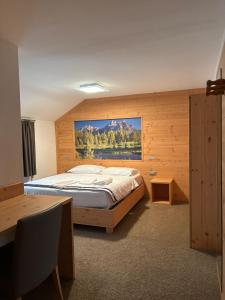 a bedroom with a bed with a painting on the wall at Chalet Monte Coston in Lastebasse