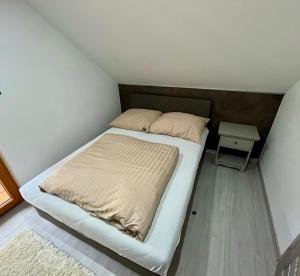 a small bedroom with a bed and a table at Zrub u Pongrácza v Panoráma Parku in Nezbudská Lúčka
