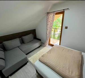 a living room with a couch and a window at Zrub u Pongrácza v Panoráma Parku in Nezbudská Lúčka
