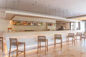 a bar with a row of chairs in a room at Canyamel Sun Suites Hotel in Canyamel