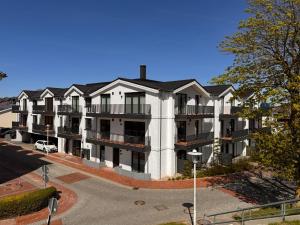 an apartment building with balconies on a street at Boardinghouse in Büsum