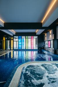 a large swimming pool in a building at Altus Hotel & Spa in Praid