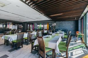 a dining room with tables and chairs and windows at Altus Hotel & Spa in Praid