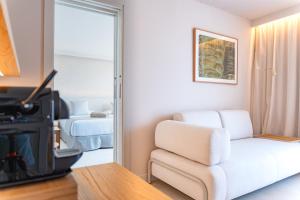 a living room with a white chair and a stove at Canyamel Sun Suites Hotel in Canyamel