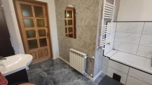 a bathroom with a sink and a toilet and a door at Vikos-Spa in Rzeczyca +27 photos