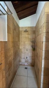 a bathroom with a shower with tiled walls at Curlt stays in Kampala