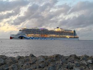 a large cruise ship in the water with at Gasthaus zur Grenze Zeltplatz in Cuxhaven +8 photos