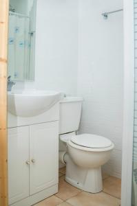 a white bathroom with a toilet and a sink at Studio Anse L'Etang in Tartane
