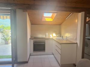 a small kitchen with a stove and a window at da rifare 1 in Solto Collina +7 photos