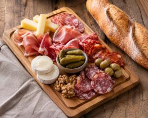 a tray of meats and cheese and bread on a table at Tiny house cosy au cœur des bois in Arsac-en-Velay