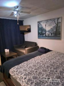 a bedroom with a bed and a couch and a ceiling fan at Casa Blanca Zandvoort in Zandvoort