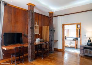 a living room with wooden walls and a table with chairs at บ้านริมดอย แม่ริม in Ban Mae Raem