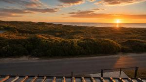 a view of a road with the sunset in the background at Sea Mist Villa in Pearly Beach