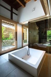 a large white bath tub in a room with a window at 一乗谷 朔 saku in Fukui +45 photos