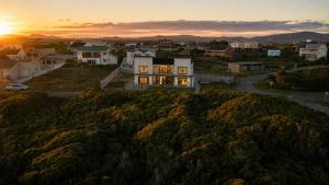 a house on a hill with the sunset in the background at Sea Mist Villa in Pearly Beach +81 photos