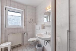 a white bathroom with a toilet and a sink at Parkblick Doppelzimmer 26, 29 in Bad Dürrheim +41 photos