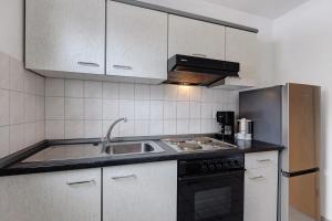 a kitchen with a sink and a stove at Parkblick Doppelzimmer 26, 29 in Bad Dürrheim