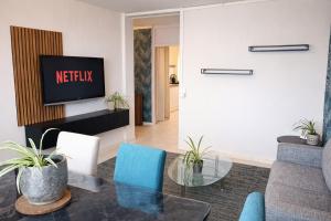 a living room with a tv and a glass table at Chambre 3 privée lit double Béthune centre in Béthune